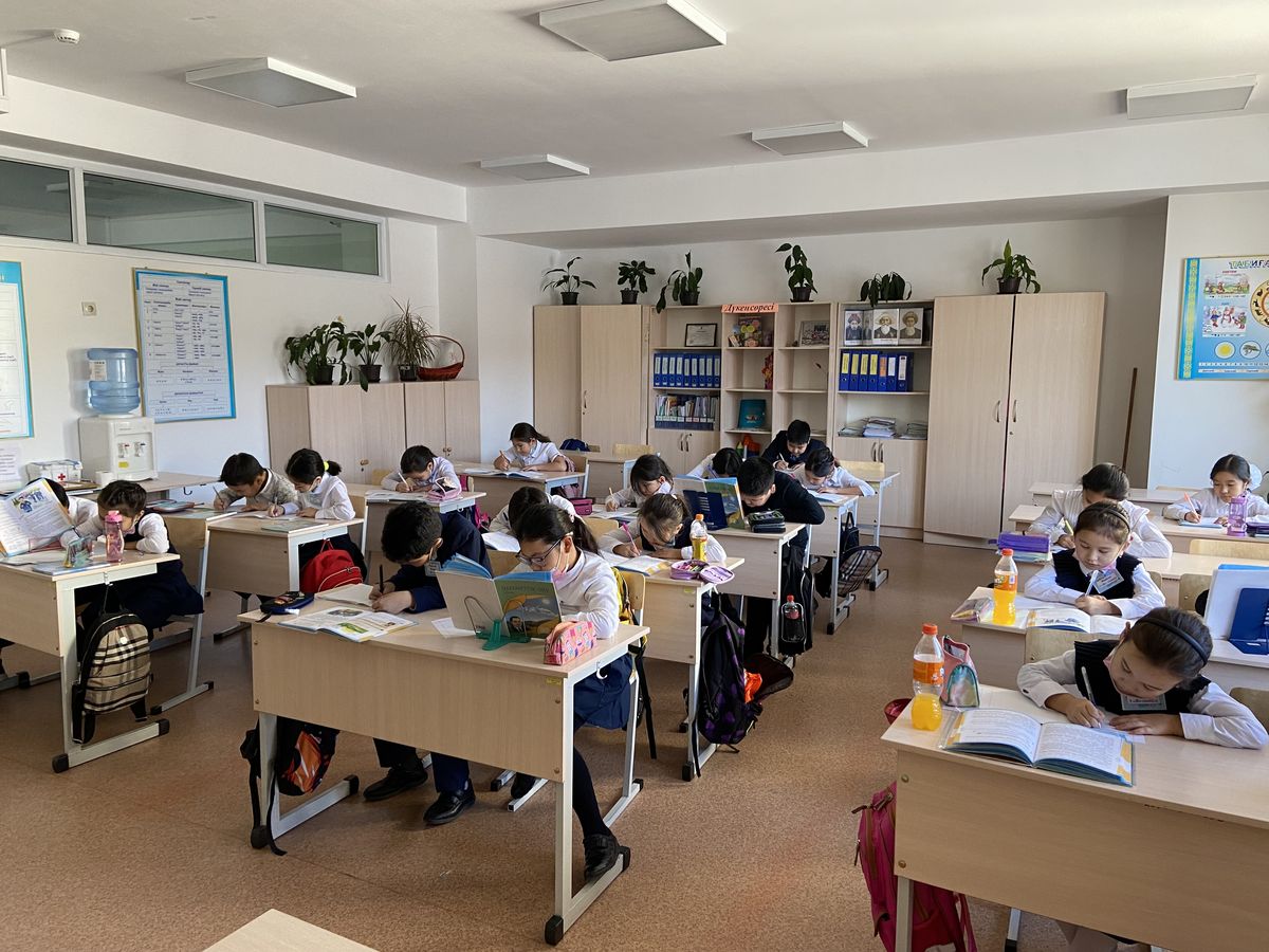 Žáci studují dějepis s učebnicí ve třídě